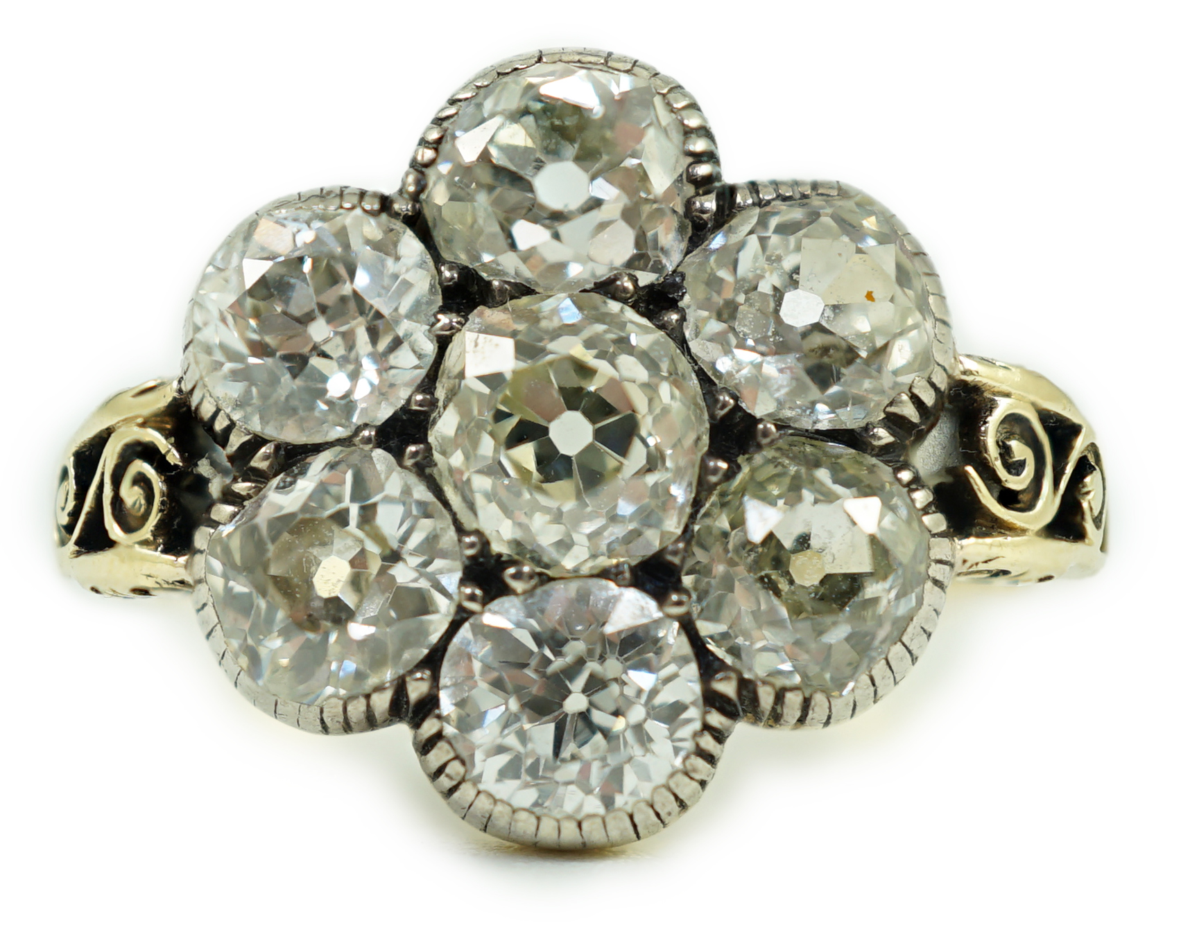 A late 19th/early 20th century gold and collet set seven stone old round cut diamond flower head cluster ring